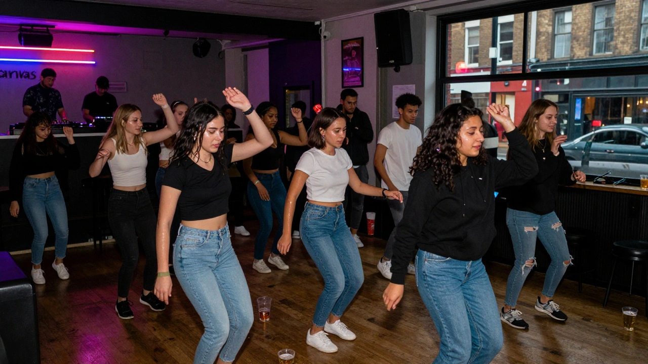 Crowd dancing at a no-cover student night club in Dalston under colorful neon lights.
