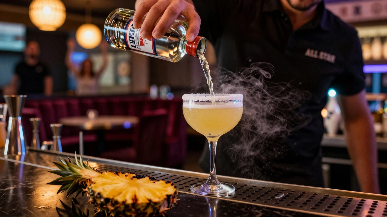 A mixologist pouring a sugar-rimmed cocktail shaped like a bowling pin with glowing garnishes.